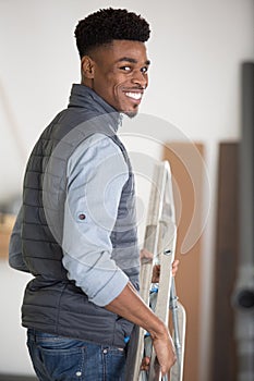 male worker carrying stepladder