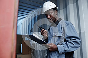 Male worker checking containers at shipping dock