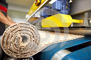 Male worker cleaning carpet on automatic washing machine equipment and dryer in the Laundry room. professional washing