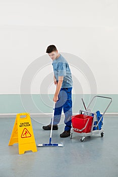 Male Worker With Cleaning Equipments Mopping Floor