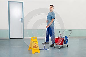 Male Worker With Cleaning Equipments Mopping Floor