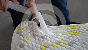 Male Worker Cleaning a mattress With Vacuum Cleaner.Professionally extraction method. Upholstered furniture. Mattress