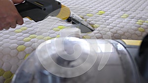 Male Worker Cleaning a mattress With Vacuum Cleaner.Professionally extraction method. Upholstered furniture. Mattress