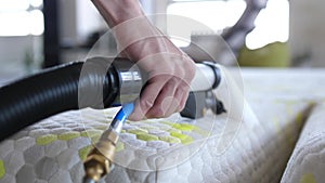 Male Worker Cleaning a mattress With Vacuum Cleaner.Professionally extraction method. Upholstered furniture. Mattress