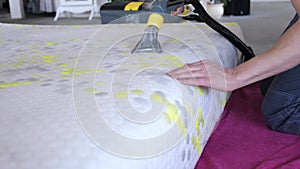 Male Worker Cleaning a mattress With Vacuum Cleaner.Professionally extraction method. Upholstered furniture. Mattress