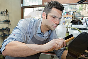 male worker cleaning shoes with brush