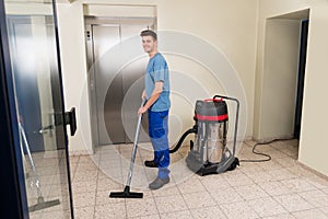 Male Worker Cleaning With Vacuum Cleaner