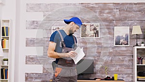 Male worker in coveralls being confused while reading instructions