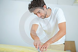 male worker cutting material