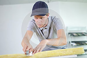 male worker cutting mineral wool