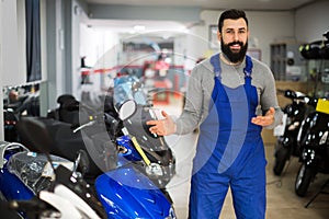 Male worker demonstrates models of motorcycles