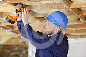male worker drilling ceiling