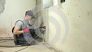 Male worker drills hole under socket