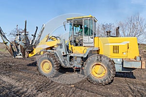 Male worker drives tree transplanter heavy machine. Landscaping, seasonal agricultural engineering, large trees landing machines.