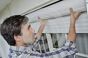 male worker fitting window shutters