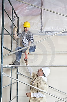 Maschio lavoratore Dare perforare sul una donna sul impalcatura sul costruzione pagine 