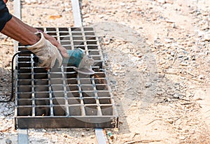 Male worker grinding at grille weld plate