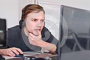Male worker with headphones. Design Office With Workers At Desks. Program developer working at his desk. Virtual office operator. photo
