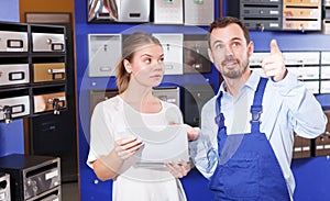 Male worker helping young consumer woman looking new mailbox