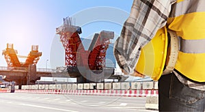 Male worker holding safety helmet works at construction site or in the field work highway construction project on a different leve