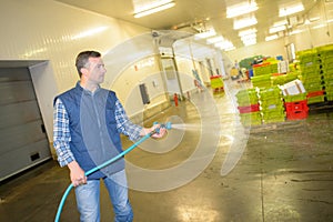 male worker hosing floor