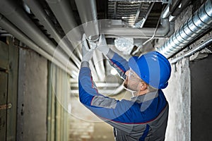 Male Worker Inspecting Pipes