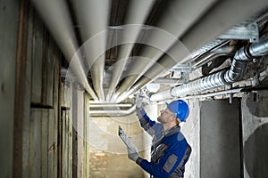 Male Worker Inspecting Pipes