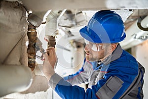Male Worker Inspecting Valve photo