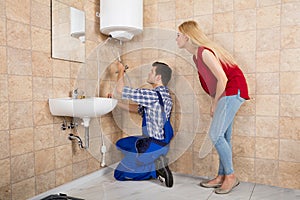 Male Worker Installing Electric Boiler With Screwdriver