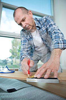 male worker lying parquet floor board- laminate flooring