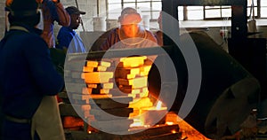 Male worker mixing molted metal in container at workshop 4k