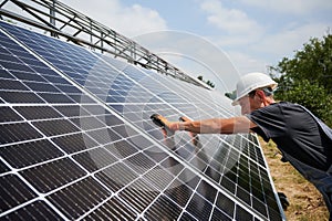 Male worker mounting photovoltaic solar panel system outdoors.