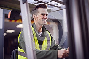 Male Worker Operating Fork Lift Truck At Freight Haulage Business photo