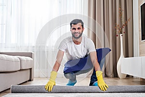 Close up of man unrolling carpet. Cleaning service concept