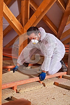 Male worker placing a rock wool thermal insulating panel between