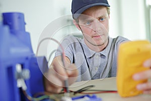 Male worker reading voltmeter