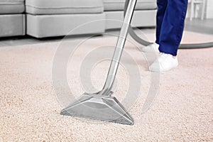 Male worker removing dirt from carpet