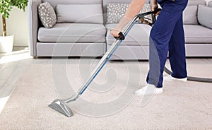 Male worker removing dirt from carpet