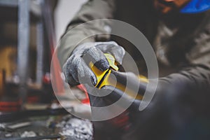 Male worker repairing Stone, edge sharpening in ski service workshop, sliding surface of the skis. sharpening of an edging of a mo