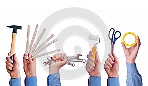 Male worker's hand holding various craft trade tools