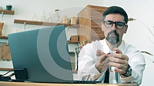 Male worker sanitizes hands with gels during quarantine.