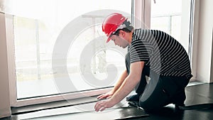 Male worker with scissors cutting teflon underlay mat