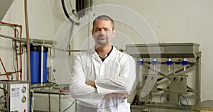 Male worker standing with arms crossed in factory 4k