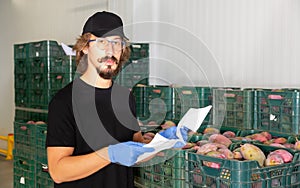 Male worker standing with papers in warehouse