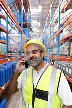 Male worker talking on mobile phone in warehouse