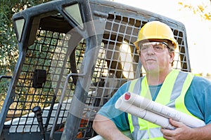 Male Worker With Technical Blueprints at Construction Site