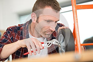 male worker trying to fix trolley wheels