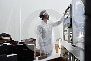 Male worker using machinery for packing foodstuffs