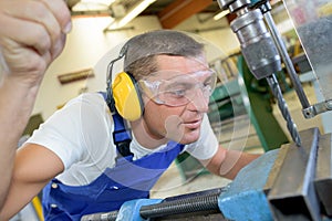 Male worker using metal drilling