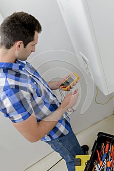 Male worker using multi meter
